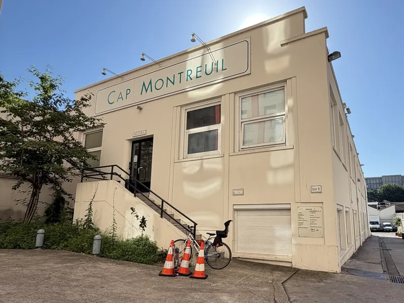 Le bâtiment B : façade claire avec l’enseigne « Cap Montreuil », entrée en haut d’un escalier.