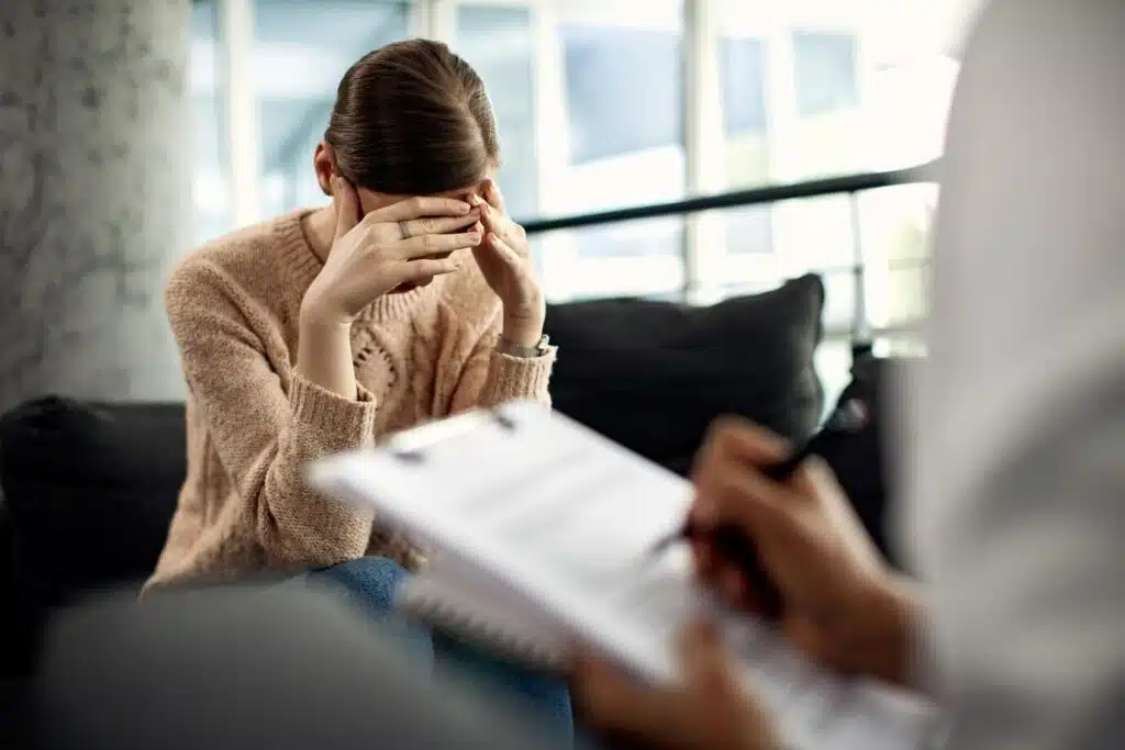 Psychothérapeute féminine écrivant des notes, pendant la thérapie avec une patiente